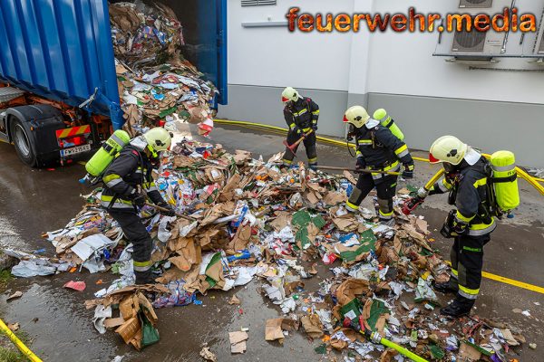 Brennender Abfallcontainer neben einem Supermarkt