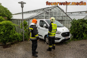 Transporter steckt rückwärts in einem Glashaus