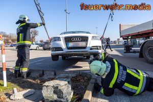 Pkw sitzt auf einem Parkplatz auf einem Stein auf