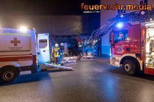 Feuerwehrkräfte tragen Patienten durch ein enges Stiegenhaus
