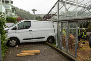 Transporter steckt rückwärts in einem Glashaus