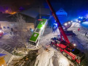 Autobus rutscht auf Schneefahrbahn von der Straße und stürzt ab