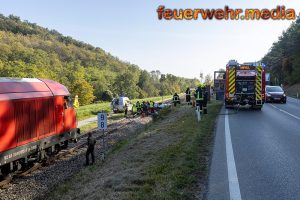 Fahrzeug stürzt von der L100 auf das Gleisbett der Bahn