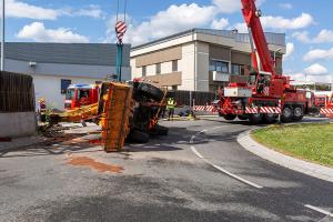 Unimog stürzt in einem Kreisverkehr um und durchbricht eine Lärmschutzwand