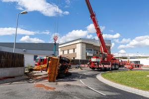 Unimog stürzt in einem Kreisverkehr um und durchbricht eine Lärmschutzwand