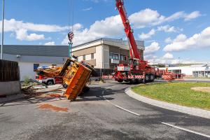 Unimog stürzt in einem Kreisverkehr um und durchbricht eine Lärmschutzwand