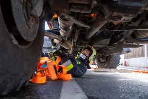 Unimog stürzt in einem Kreisverkehr um und durchbricht eine Lärmschutzwand