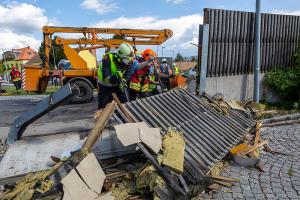 Unimog stürzt in einem Kreisverkehr um und durchbricht eine Lärmschutzwand