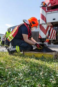 Unimog stürzt in einem Kreisverkehr um und durchbricht eine Lärmschutzwand