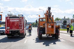 Unimog stürzt in einem Kreisverkehr um und durchbricht eine Lärmschutzwand