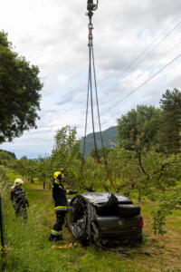 Pkw landet nach Kollision mit einem Autobus in einem Marillengarten
