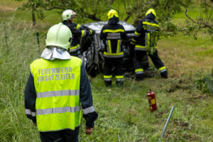 Pkw landet nach Kollision mit einem Autobus in einem Marillengarten